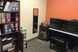 Piano learning resources organized in a music room.